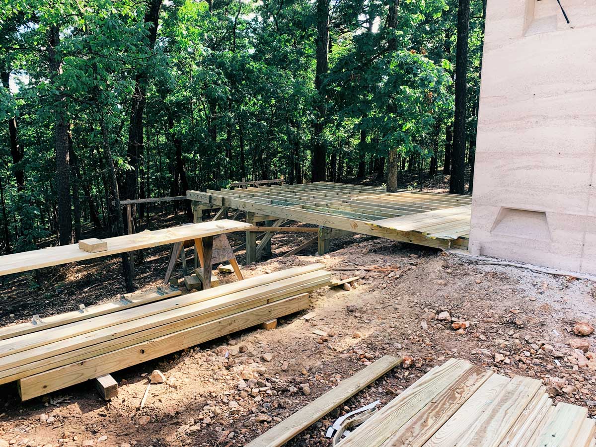 A modern wood deck under construction at the rammed earth house project in Eureka Springs, AR