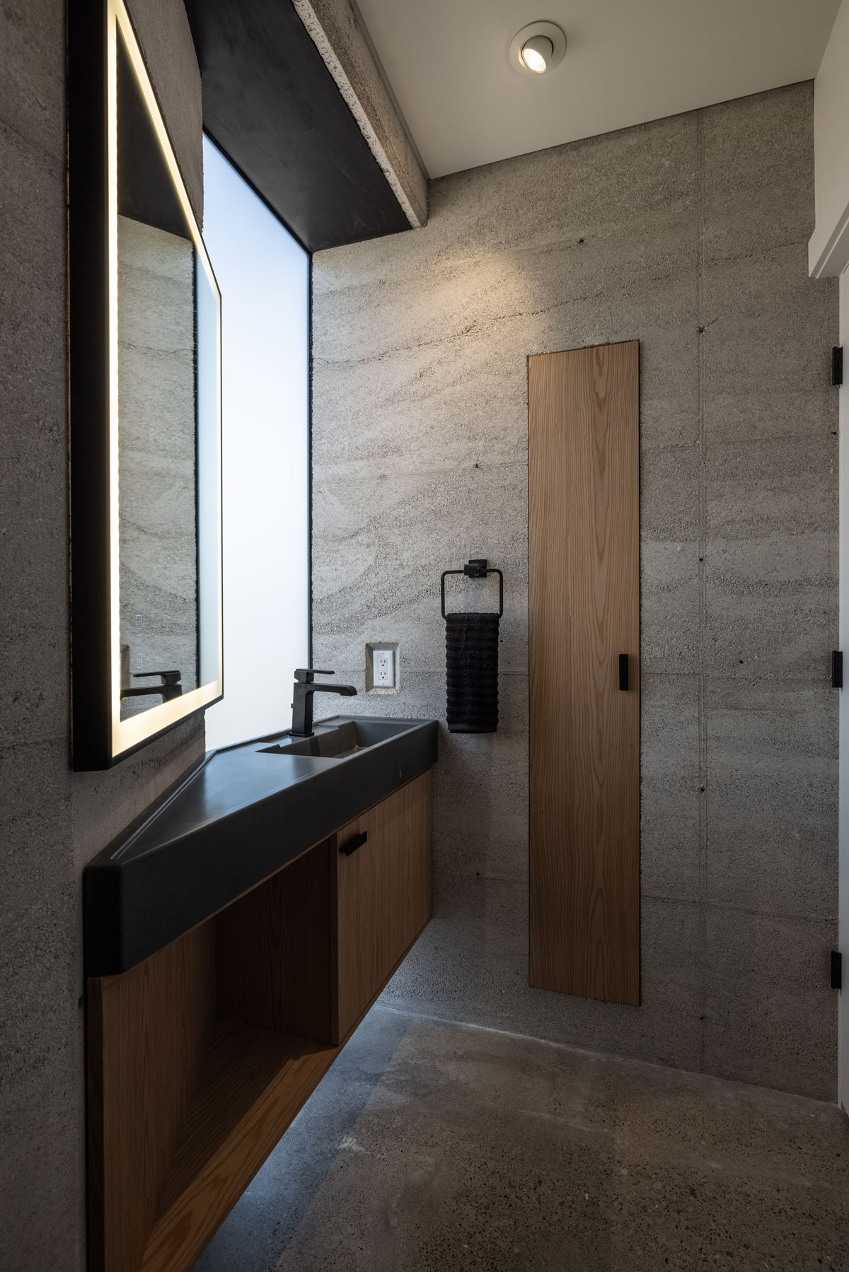 The powder bath in the rammed earth cabin, featuring a stunning concrete sink