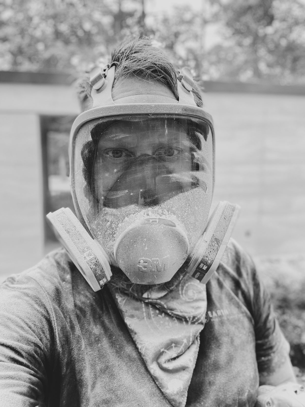 a photo of brandon gore, furniture and home builder, just after grinding into a limestone rammed earth wall