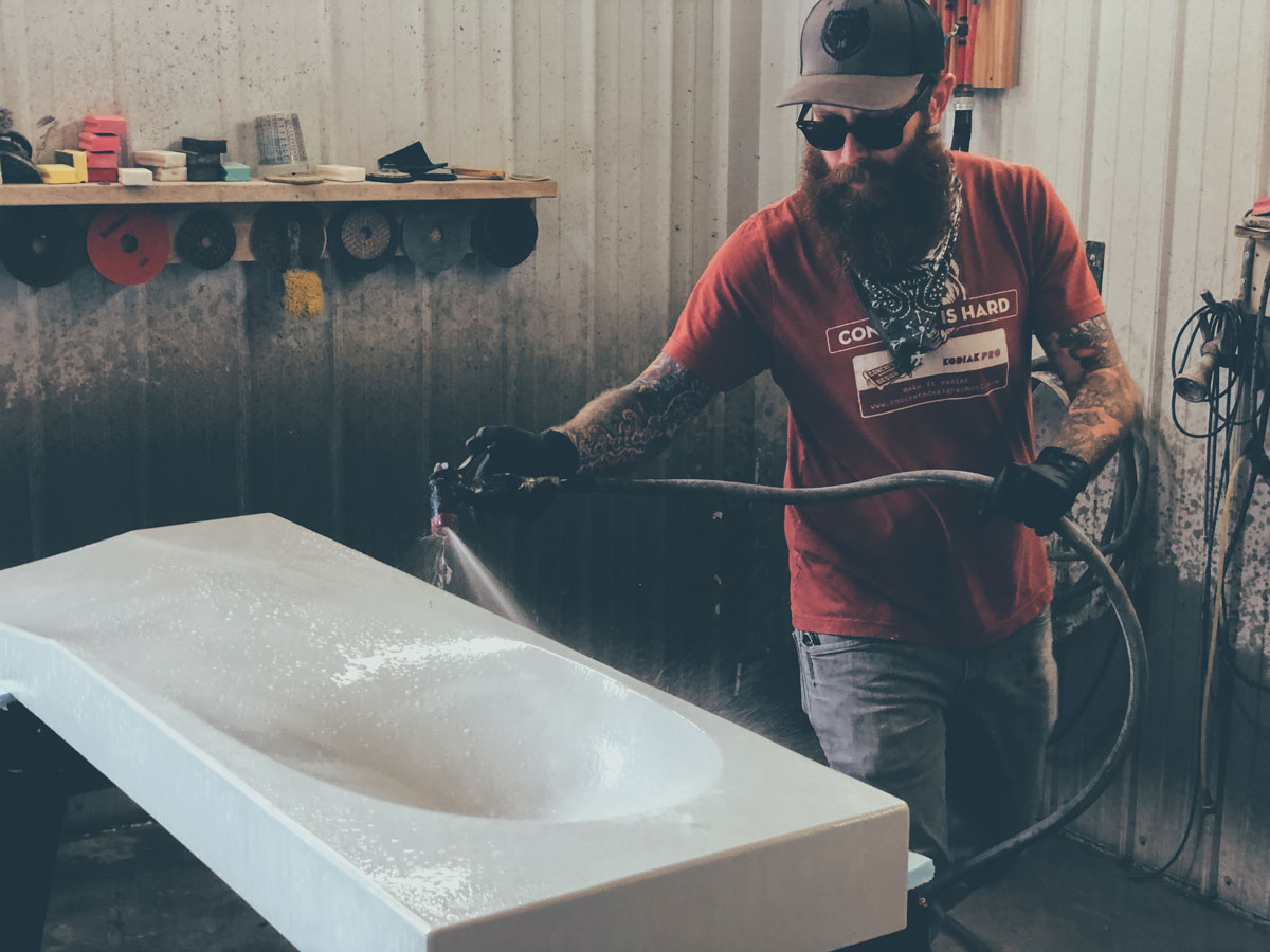 Brandon Gore processing a GFRC concrete sink in preparation of concrete sealer