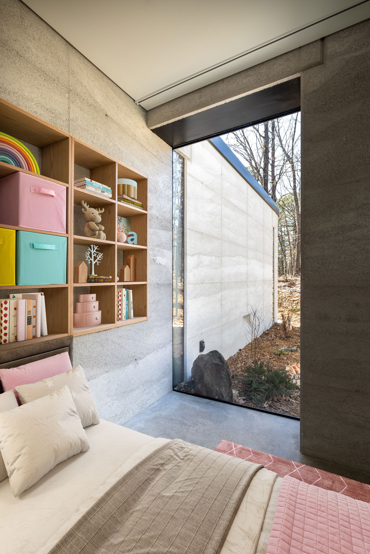 A large glass window blurs the line between interior and exterior spaces in this modern rammed earth cabin located in Eureka Springs, AR, USA