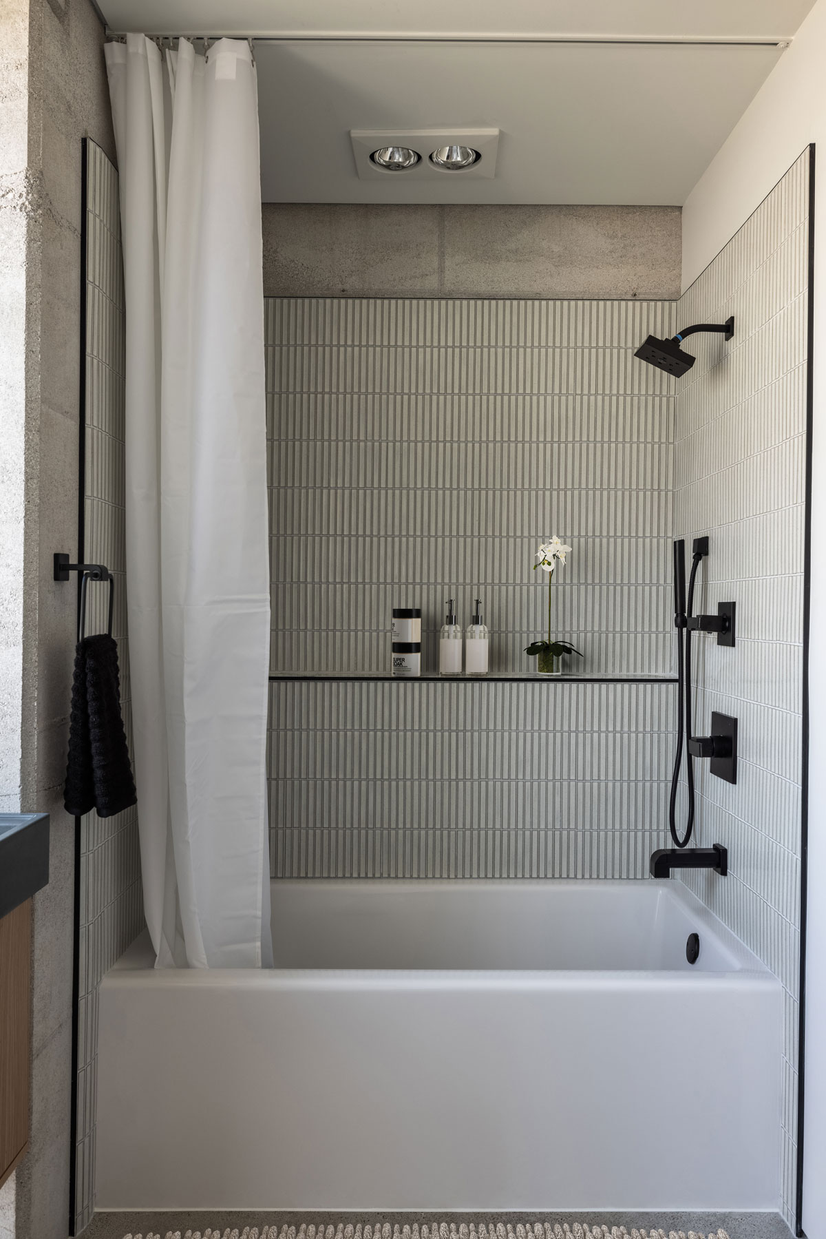 Japanese ceramic tile frame this simple tub in a rammed earth bathroom