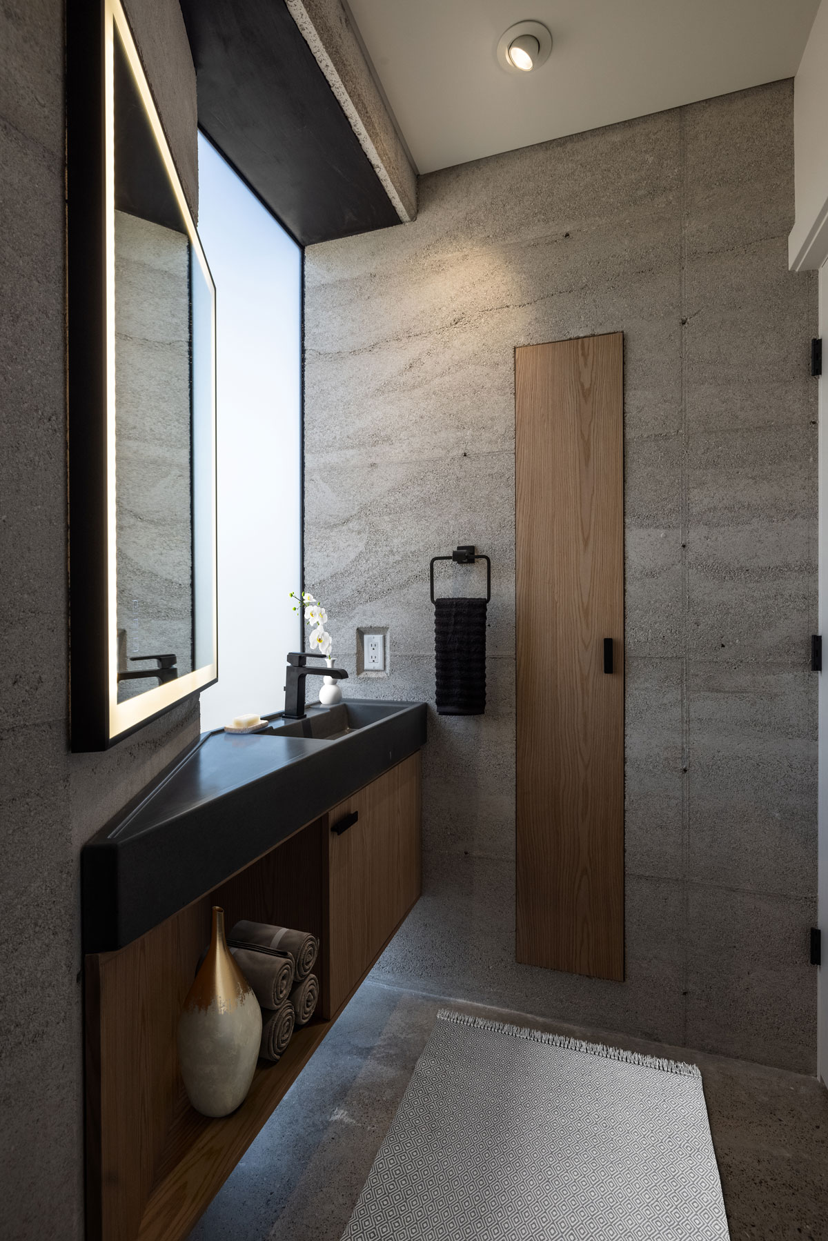 The powder bath in the modern CALX Cabin rammed earth house showcases this bespoke concrete sink and floating cabinet handcrafted in the USA by Hard Goods.