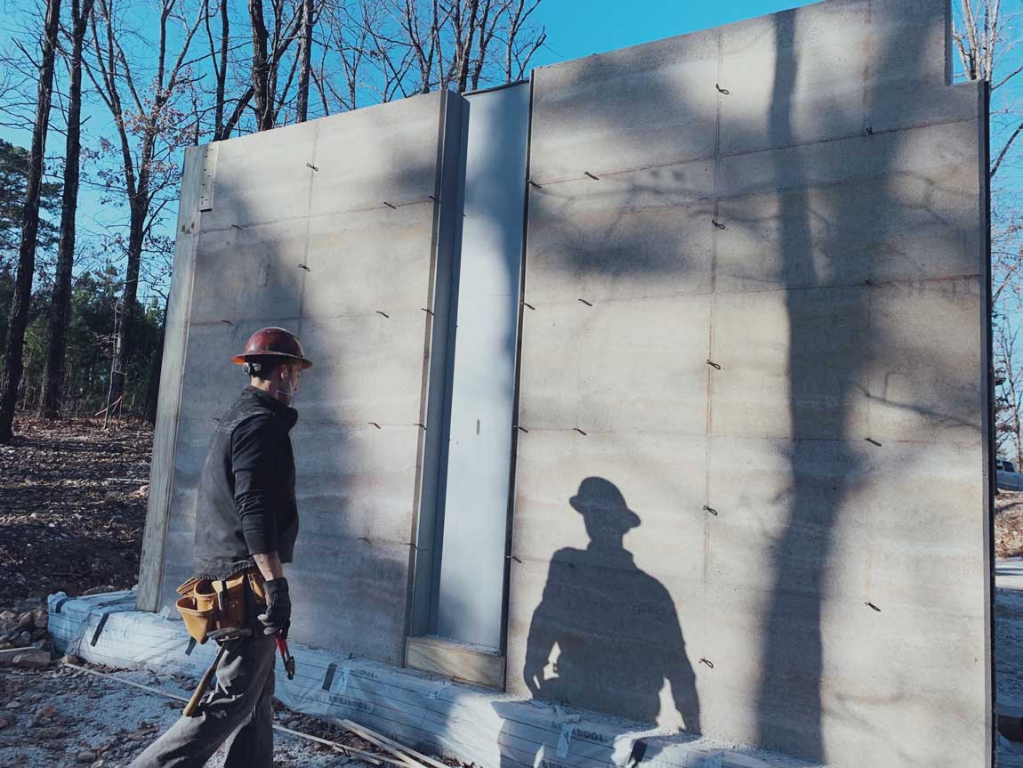 a concrete scupper in a freshly de-molded rammed earth wall