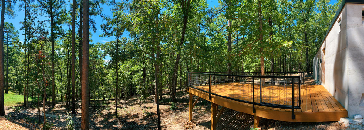 The wood deck off the back of the sustainable modern cabin in the Ozarks