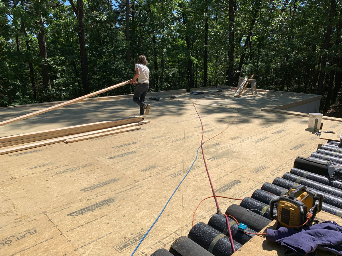 the roof is nearly complete on this rammed earth cabin