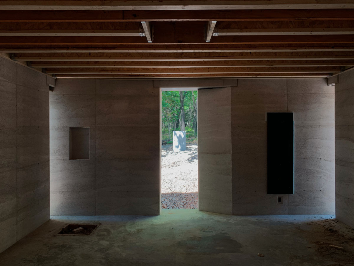 light and shadow dancing on rammed earth walls in a modern custom home