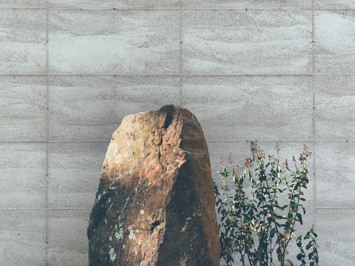 A rammed earth wall and a boulder